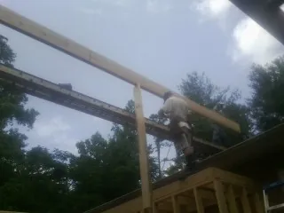 Carpenter setting a ridge beam over a new addition frame — Ice Dam Removal by Roofing Brothers in Stony Creek
